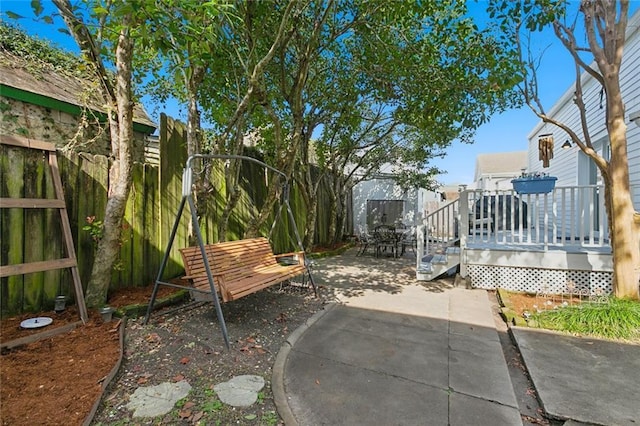 view of yard featuring a wooden deck and a patio