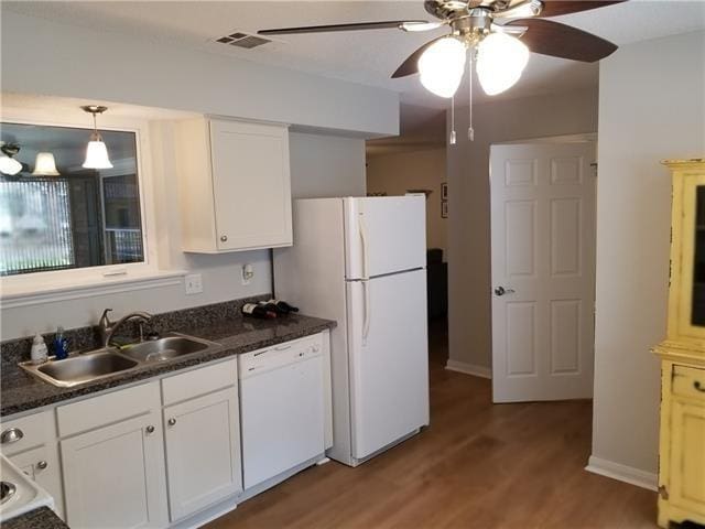 kitchen featuring white cabinetry, white appliances, sink, and hardwood / wood-style floors