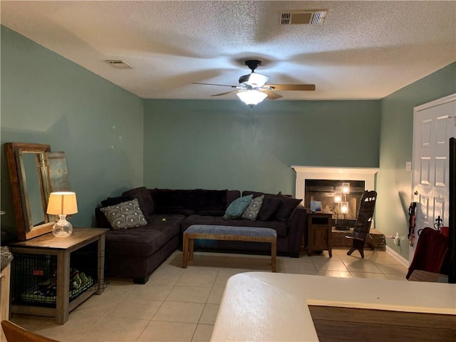 tiled living room featuring a textured ceiling and ceiling fan