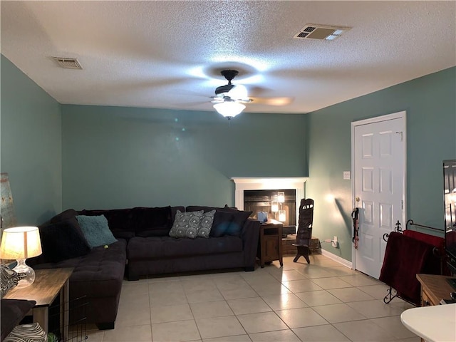 tiled living room with ceiling fan and a textured ceiling