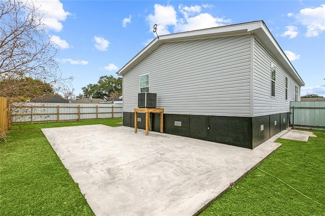 back of house with a patio and a lawn