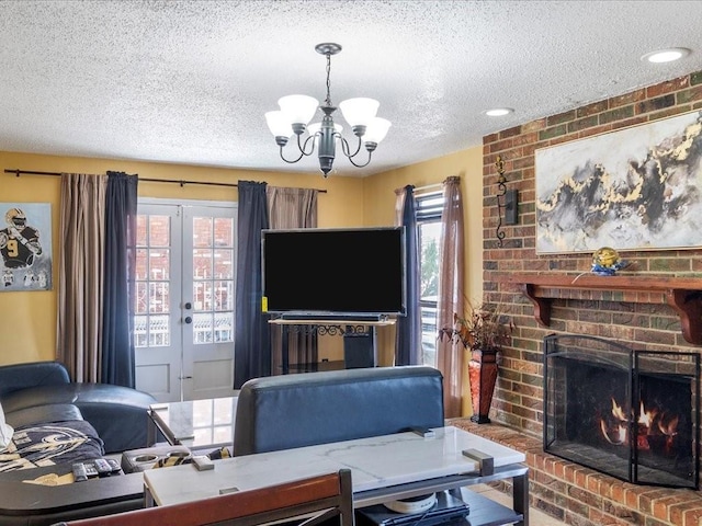 living room with french doors, a fireplace, a textured ceiling, and a notable chandelier