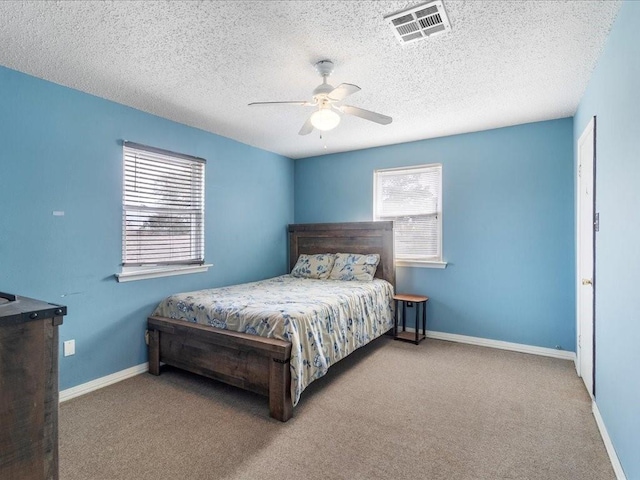 carpeted bedroom with a textured ceiling and ceiling fan