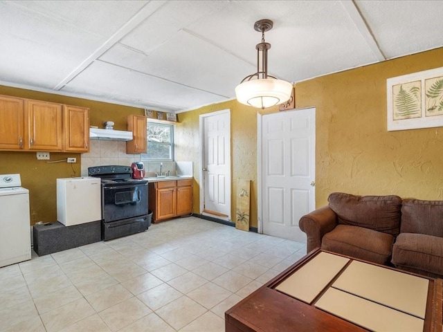 kitchen featuring black electric range oven, sink, hanging light fixtures, light tile patterned floors, and washer / clothes dryer