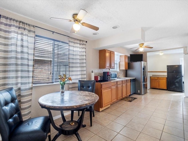 kitchen featuring sink, a textured ceiling, light tile patterned floors, appliances with stainless steel finishes, and ceiling fan