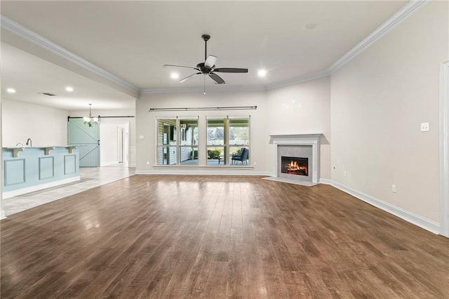 unfurnished living room featuring hardwood / wood-style flooring, ornamental molding, ceiling fan with notable chandelier, and a high end fireplace