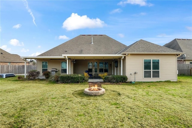 rear view of house featuring a fire pit, a lawn, and a patio area