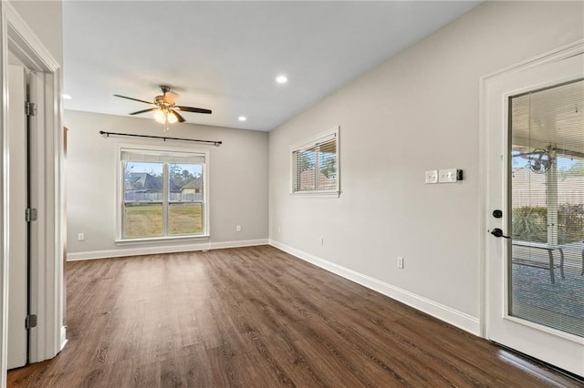 spare room with dark hardwood / wood-style flooring and ceiling fan