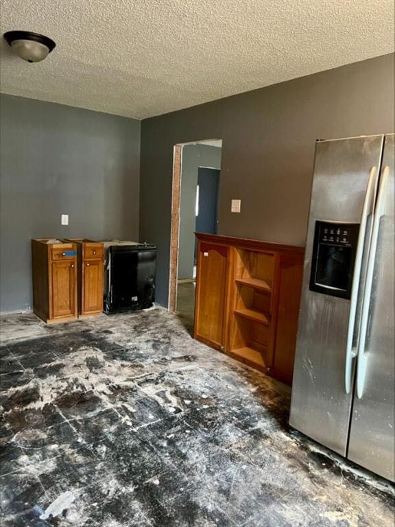 kitchen with a textured ceiling and stainless steel refrigerator with ice dispenser