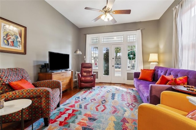 living room with lofted ceiling, hardwood / wood-style floors, french doors, and ceiling fan