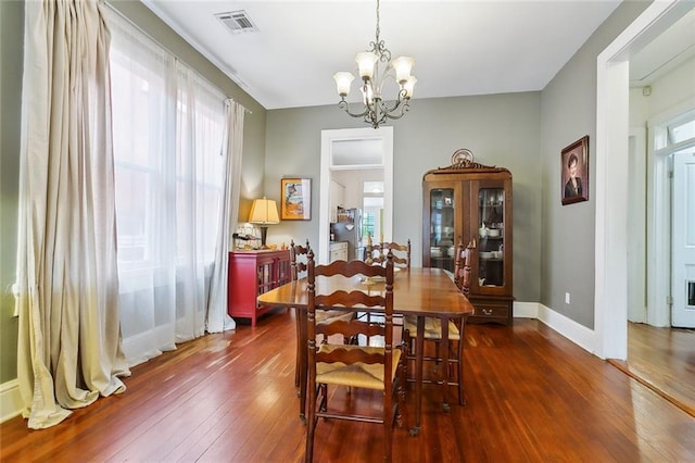 dining space featuring an inviting chandelier and dark hardwood / wood-style flooring