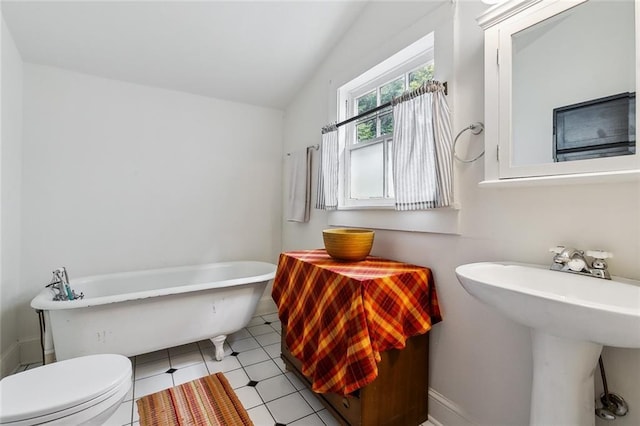 bathroom featuring lofted ceiling, sink, a tub, and toilet