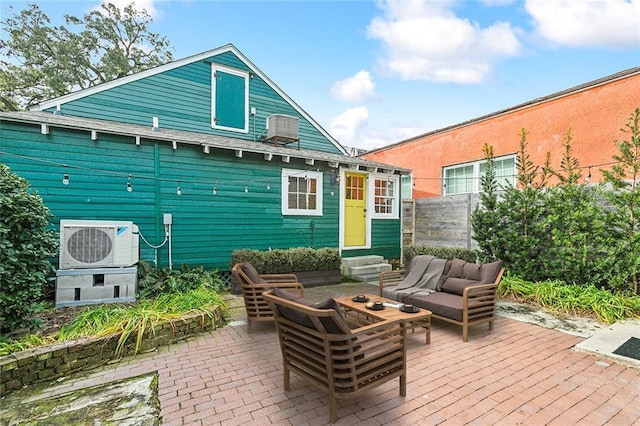 rear view of house with an outdoor living space, a patio area, and ac unit