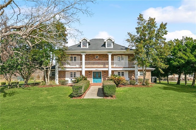 back of property with a yard and a balcony