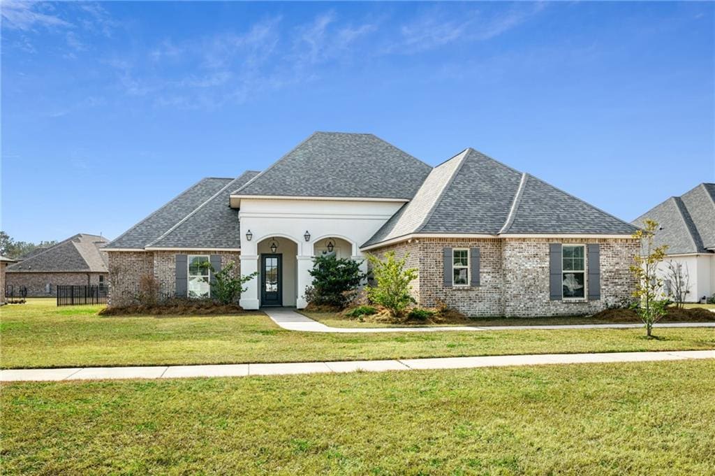 french country style house with a front lawn