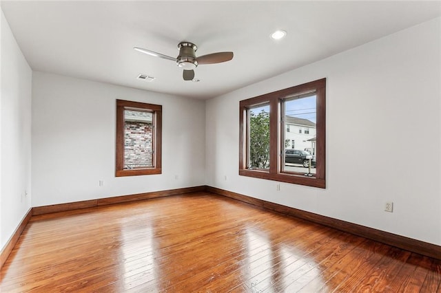 spare room featuring plenty of natural light, light hardwood / wood-style floors, and ceiling fan