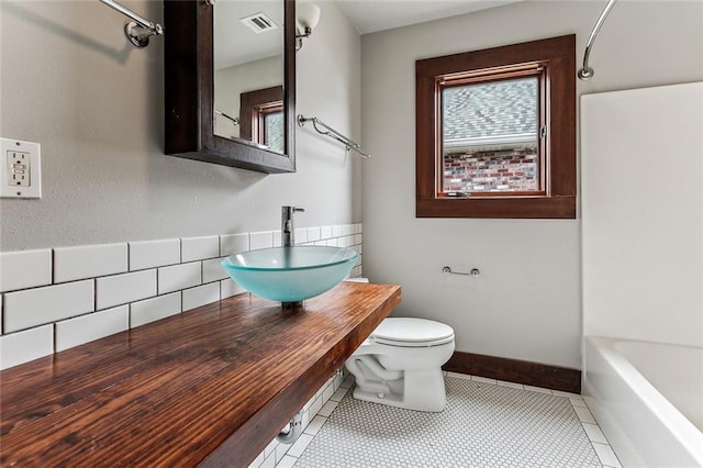 full bathroom featuring tile patterned flooring, sink, tub / shower combination, and toilet