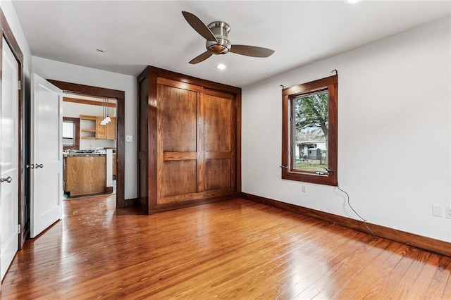 unfurnished bedroom featuring ceiling fan, hardwood / wood-style floors, and a closet