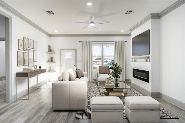 26 Carroll Dr, Chalmette, LA 70043 - living room featuring a ceiling fan, crown molding, a glass covered fireplace, wood finished floors, and baseboards