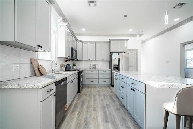26 Carroll Dr, Chalmette, LA 70043 - kitchen featuring appliances with stainless steel finishes, a sink, crown molding, a center island, and light wood finished floors