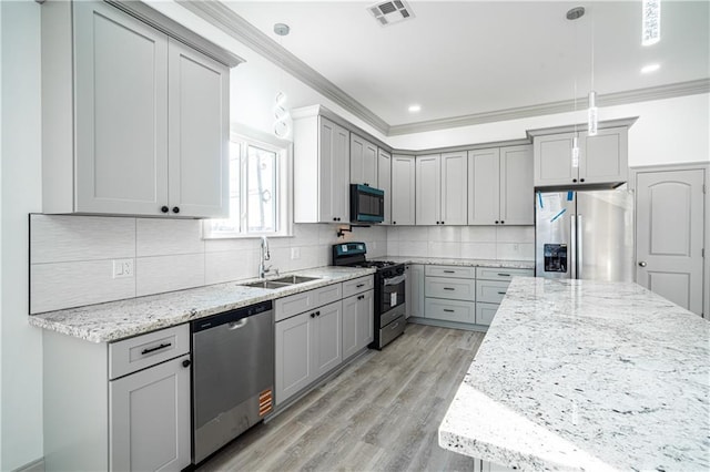 kitchen featuring pendant lighting, sink, gray cabinetry, stainless steel appliances, and light stone countertops