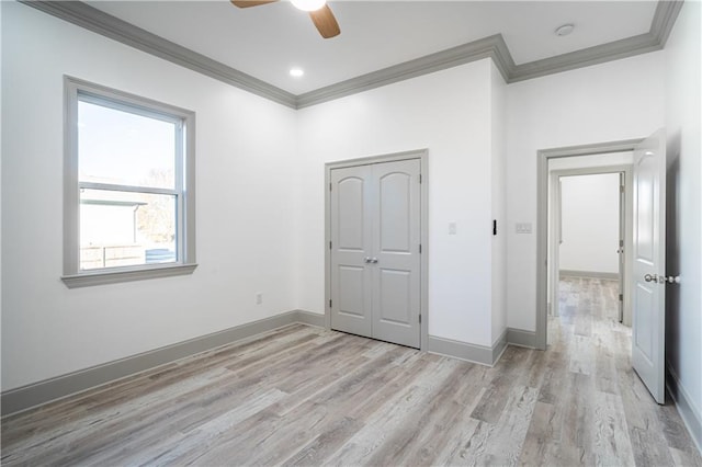 unfurnished bedroom featuring crown molding, light hardwood / wood-style floors, a closet, and ceiling fan