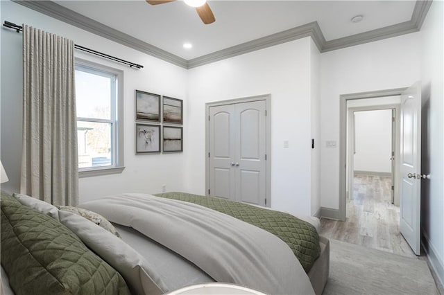 26 Carroll Dr, Chalmette, LA 70043 - bedroom featuring crown molding, light wood finished floors, a ceiling fan, baseboards, and a closet