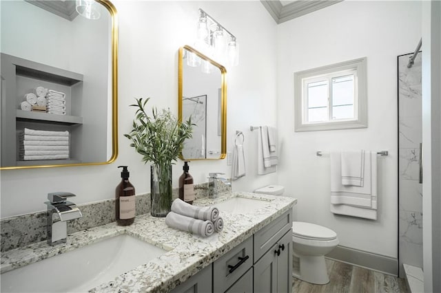26 Carroll Dr, Chalmette, LA 70043 - bathroom with wood finished floors, toilet, double vanity, crown molding, and a shower