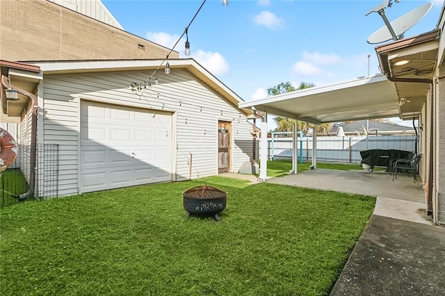 view of yard with a garage, an outdoor structure, and a fire pit