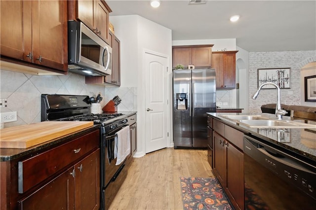 kitchen featuring sink, backsplash, black appliances, and light hardwood / wood-style floors