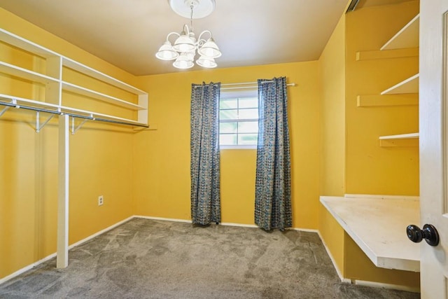 walk in closet featuring carpet and a notable chandelier