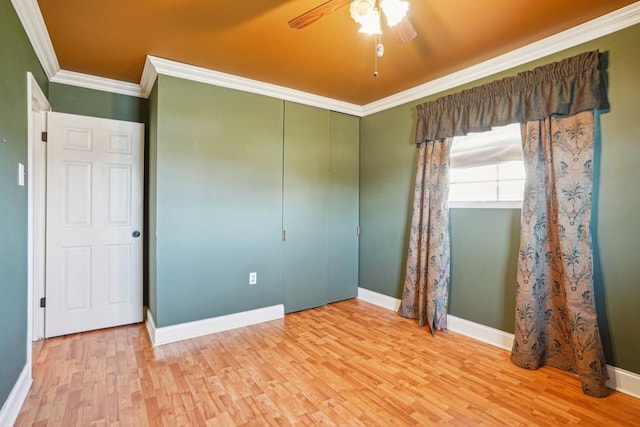 spare room featuring baseboards, a ceiling fan, crown molding, and wood finished floors