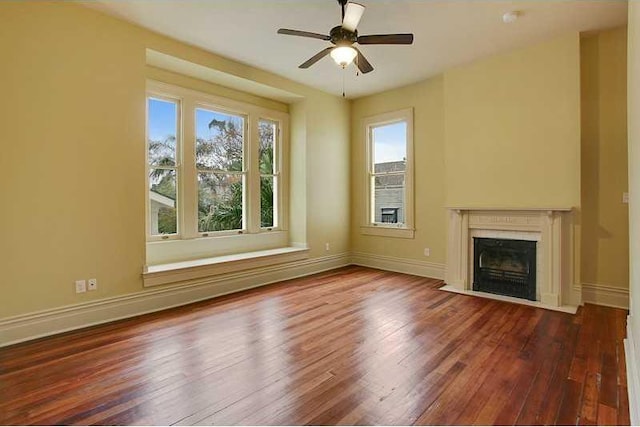 unfurnished living room featuring ceiling fan, a high end fireplace, and dark hardwood / wood-style floors