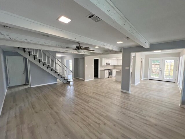 unfurnished living room featuring wood-type flooring, ceiling fan, beam ceiling, and french doors