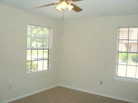 empty room featuring ceiling fan, plenty of natural light, and a textured ceiling