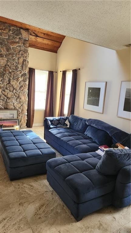 living room featuring lofted ceiling, a fireplace, and a textured ceiling