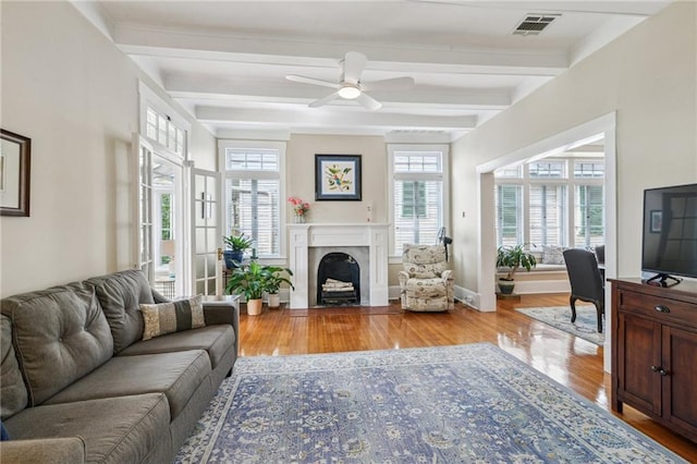 living room with beamed ceiling, ceiling fan, and light hardwood / wood-style flooring