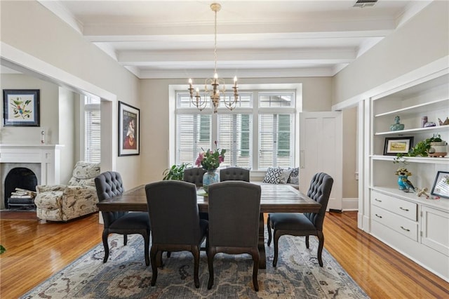 dining room featuring a chandelier, hardwood / wood-style floors, built in features, and beam ceiling