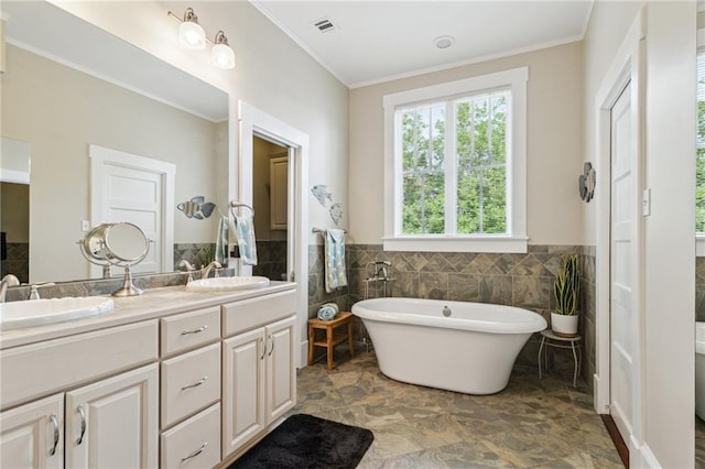 bathroom with vanity, a bath, crown molding, and tile walls