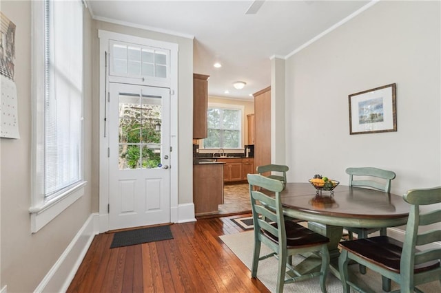 doorway to outside featuring sink, ornamental molding, and dark hardwood / wood-style floors