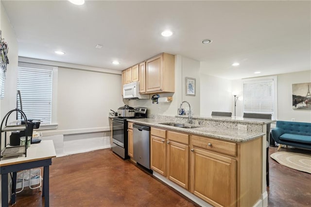 kitchen with sink, stainless steel appliances, light stone counters, kitchen peninsula, and light brown cabinets