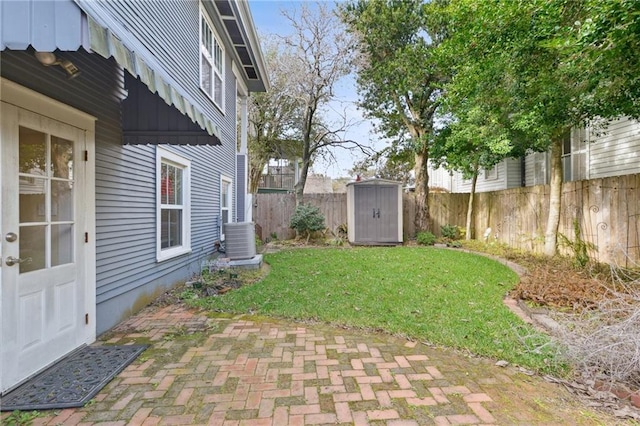 view of yard with central AC, a storage shed, and a patio area