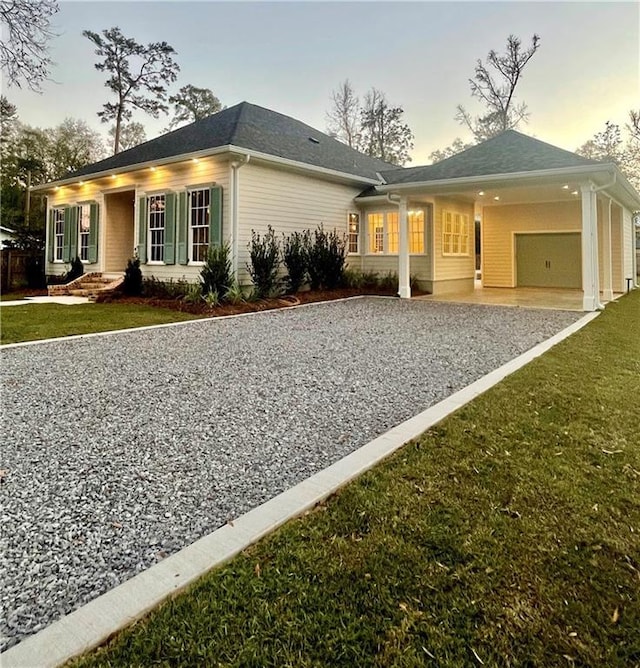 property exterior at dusk featuring a garage and a lawn