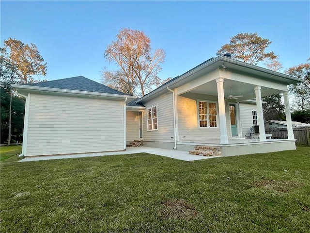 rear view of house with a patio, ceiling fan, and a lawn