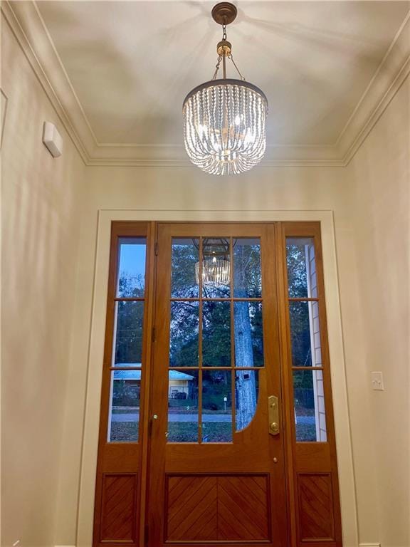 doorway with ornamental molding and a chandelier