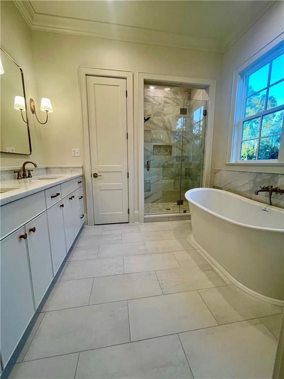 bathroom featuring vanity, crown molding, and separate shower and tub