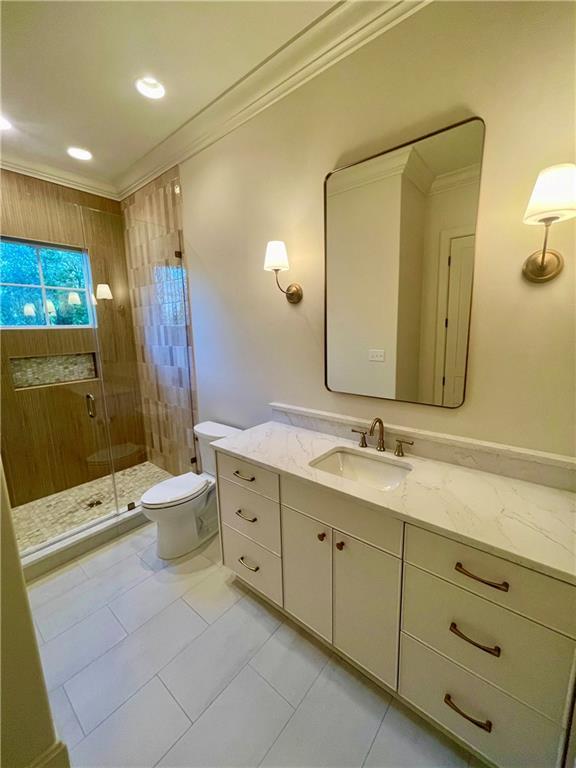 bathroom featuring vanity, an enclosed shower, ornamental molding, tile patterned floors, and toilet