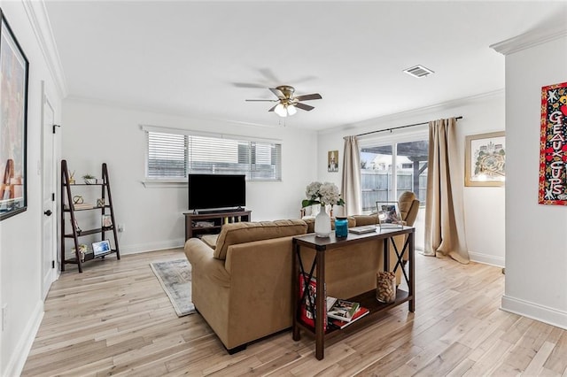 living room featuring crown molding, plenty of natural light, and light hardwood / wood-style floors