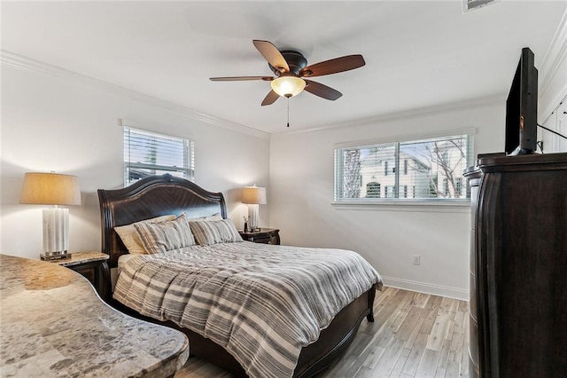 bedroom with ornamental molding, ceiling fan, and light hardwood / wood-style floors