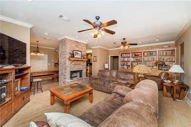 living room featuring ornamental molding, a fireplace, and light hardwood / wood-style flooring